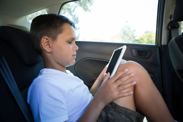 Adolescente niño usando tableta en el coche — Foto de Stock