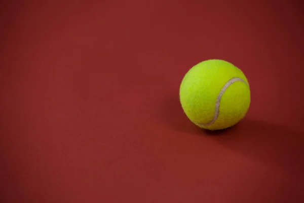 Pelota de tenis contra fondo granate —  Fotos de Stock