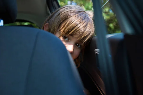 Chica adolescente sentada en el asiento trasero del coche — Foto de Stock