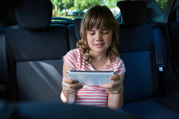Adolescente chica usando tableta en el coche — Foto de Stock