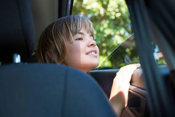 Adolescente sentada no banco de trás do carro — Fotografia de Stock