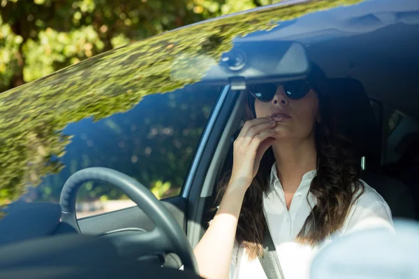Woman looking into rear view mirror — Stock Photo, Image