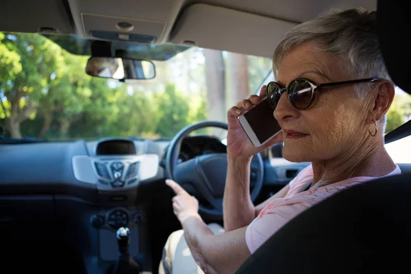 Starší žena mluví o telefonu v autě — Stock fotografie