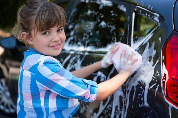 Teenager-Mädchen wäscht an einem sonnigen Tag ein Auto — Stockfoto