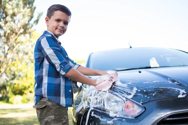 Teenager wäscht an einem sonnigen Tag ein Auto — Stockfoto