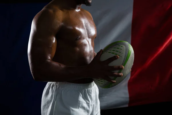Košili sportovec drží rugby míč — Stock fotografie