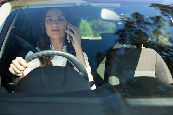 Женщина разговаривает по телефону в машине — стоковое фото
