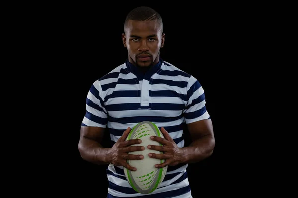 Jugador masculino serio sosteniendo pelota de rugby — Foto de Stock