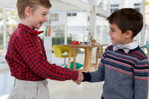 Kinderen als bedrijfsleiders handen schudden — Stockfoto