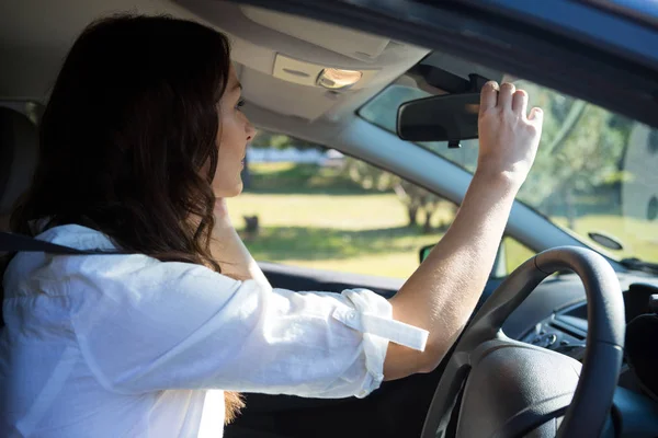 Mulher olhando no espelho retrovisor — Fotografia de Stock