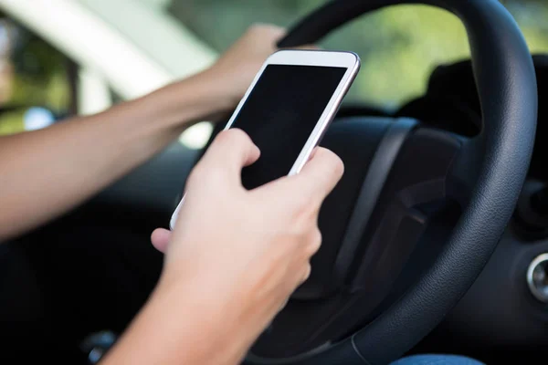 Vrouw met behulp van de telefoon tijdens het rijden auto — Stockfoto