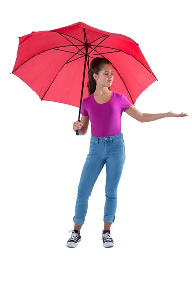 Teenage girl standing under a red umbrella — Stock Photo, Image