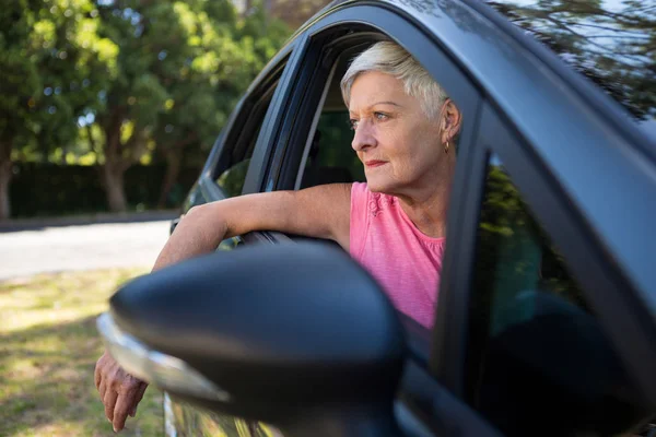 Starší žena sedí v autě — Stock fotografie