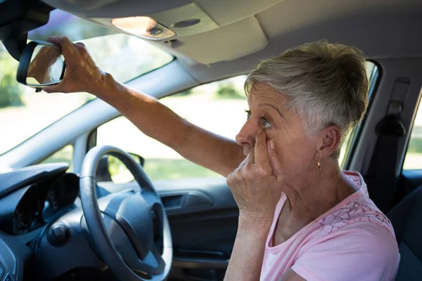 Mujer mayor mirando en el espejo retrovisor —  Fotos de Stock