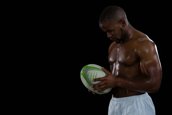 Sin camisa atleta masculino sosteniendo pelota de rugby — Foto de Stock