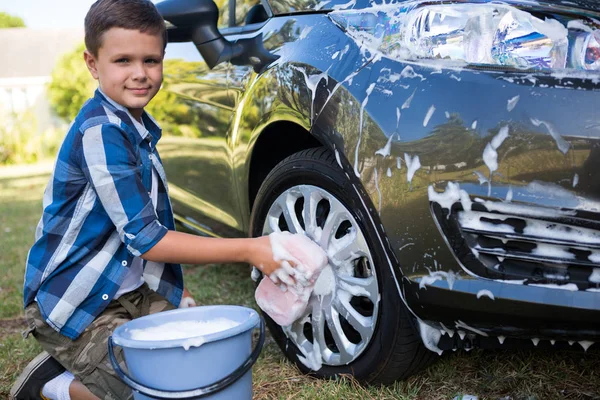 Adolescente menino lavar um carro no dia ensolarado — Fotografia de Stock