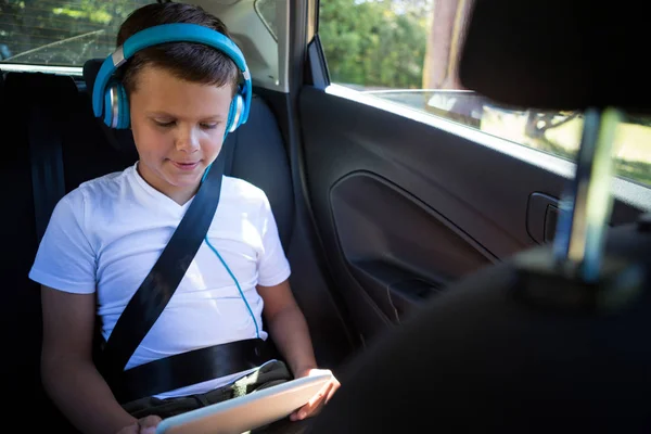 Adolescente niño usando tableta en el coche — Foto de Stock