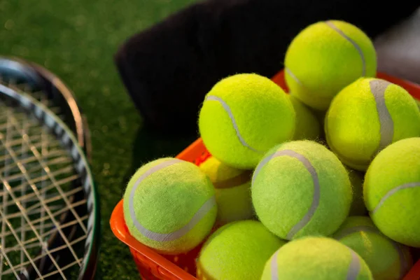 Tennisbälle im Korb mit Schlägern — Stockfoto