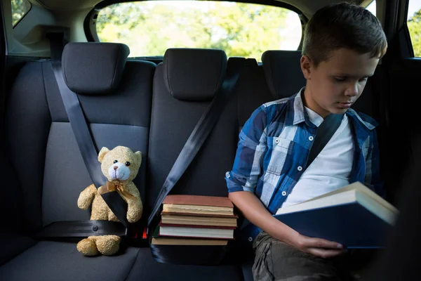 자동차에 10 대 소년 읽기 책 — 스톡 사진