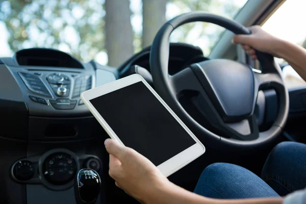 Frau benutzt Tablet während Autofahrt — Stockfoto