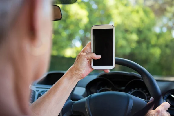 Vrouw met behulp van de telefoon tijdens het rijden auto — Stockfoto