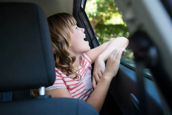 Adolescente sentada no banco de trás do carro — Fotografia de Stock