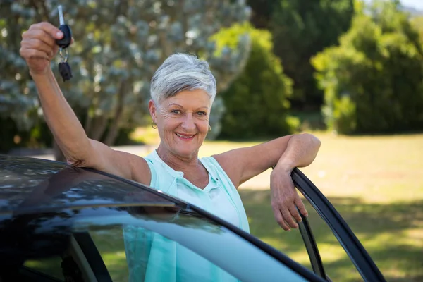 Senior vrouw een auto knop ingedrukt in park — Stockfoto