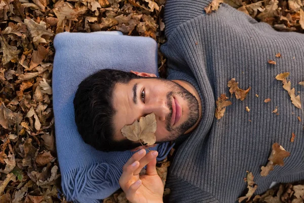 Άντρας ξαπλωμένος στο Φθινοπωρινά φύλλα — Φωτογραφία Αρχείου