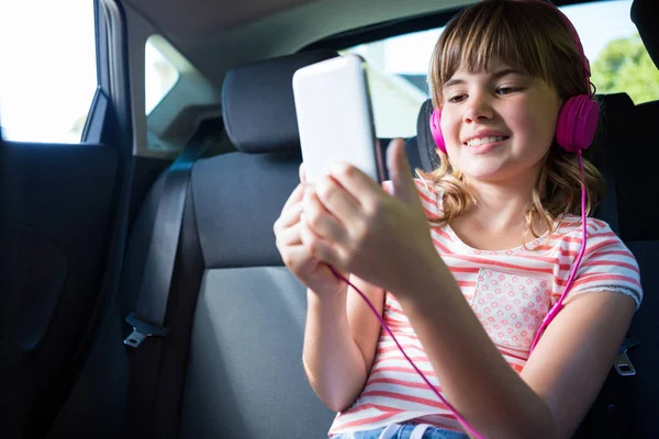 Tienermeisje in koptelefoon met behulp van Tablet PC — Stockfoto