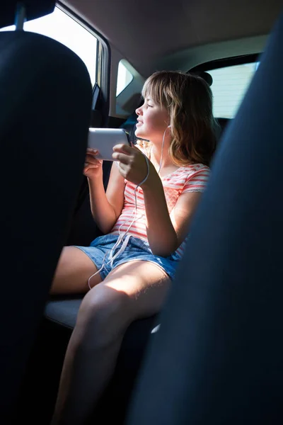Chica adolescente en auriculares usando el teléfono — Foto de Stock