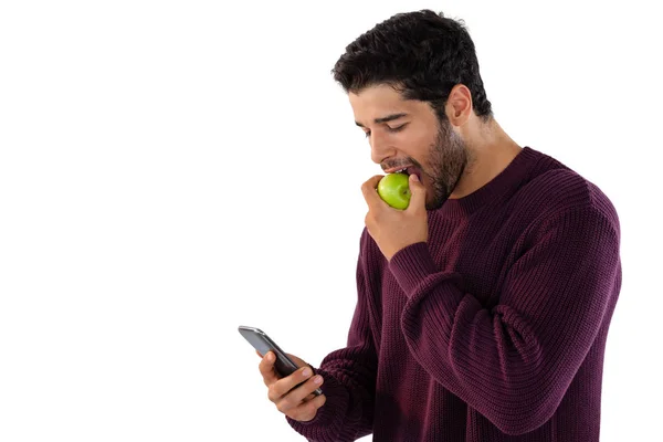 Hombre comiendo manzana mientras usa el teléfono —  Fotos de Stock