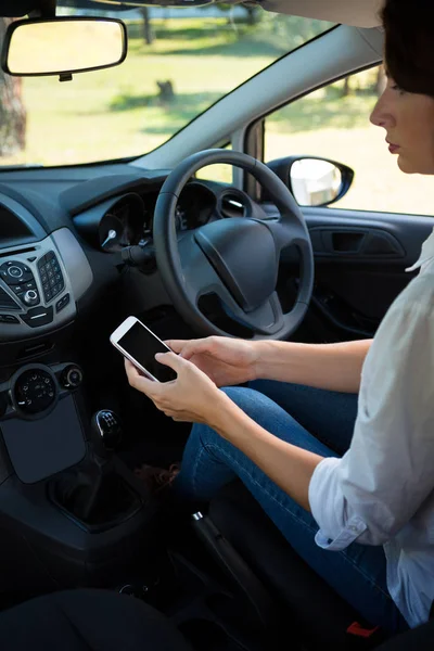 Vrouw met behulp van telefoon in een auto — Stockfoto