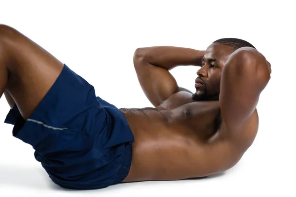 Athlète masculin torse nu pratiquant des redressements assis — Photo