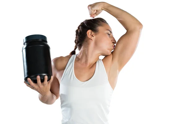 Vrouwelijke atleet holding supplement jar — Stockfoto