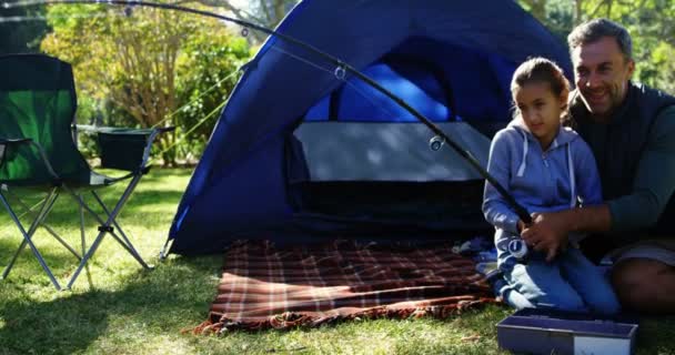 Father and son holding a fishing rod outside the tent — Stock Video