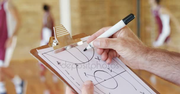 Manos del diagrama de dibujo del entrenador de baloncesto en el portapapeles — Vídeos de Stock