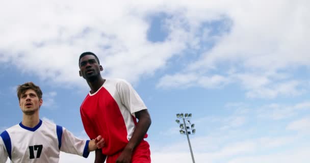 Deux joueurs de football sautant pour frapper un ballon — Video