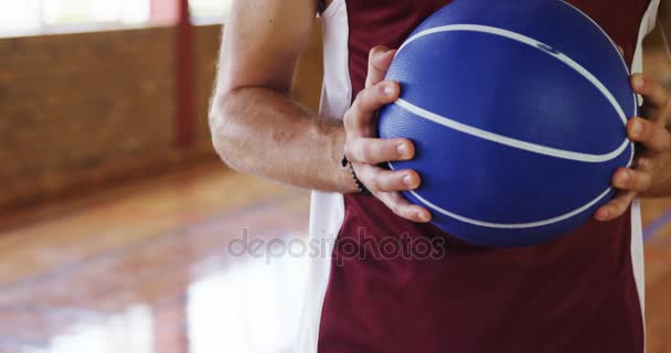 Odhodlaný basketbalový hráč drží basketbal — Stock video