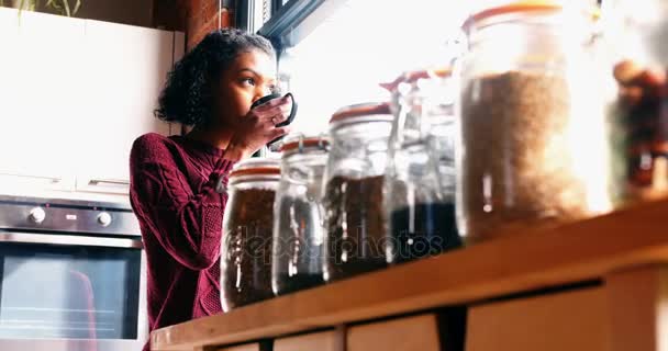 Mujer sosteniendo una taza de café cerca de la ventana — Vídeos de Stock