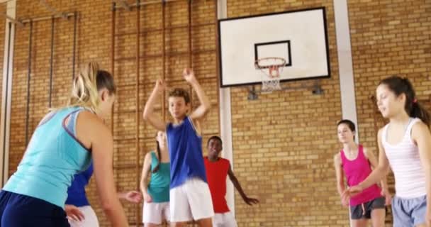Niños de secundaria jugando baloncesto en la cancha — Vídeo de stock