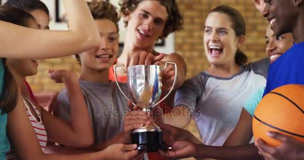 Niños de secundaria dando cinco altos mientras sostienen trofeo — Vídeos de Stock