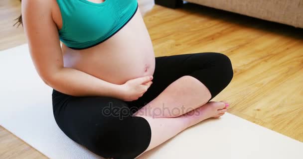 Zwangere vrouw beoefenen van yoga in woonkamer — Stockvideo