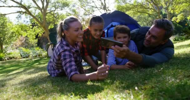Familjen tar en selfie utanför tältet — Stockvideo
