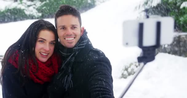 Pareja tomando selfie en el teléfono móvil durante el invierno — Vídeos de Stock