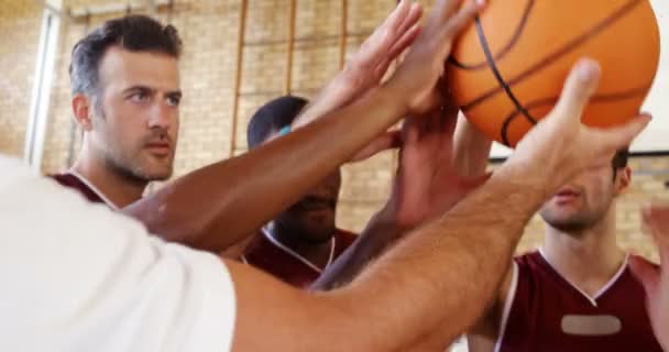 Игроки и тренер проводят баскетбол вместе на корте — стоковое видео