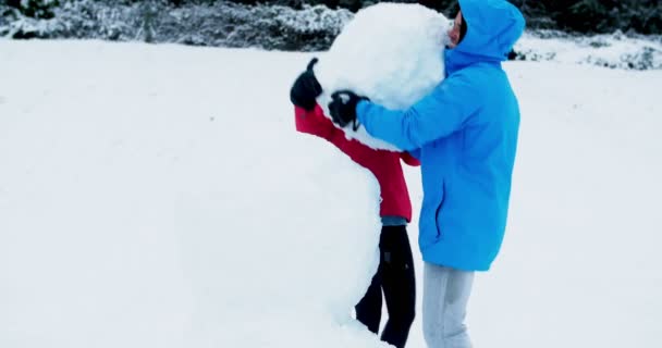 Счастливая пара делает снеговика — стоковое видео