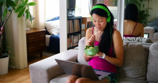 Kobieta korzysta z laptopa w czasie śniadania — Wideo stockowe