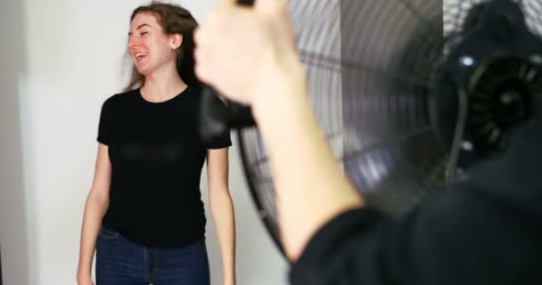 Fotógrafo sosteniendo ventilador para modelo femenino — Vídeos de Stock