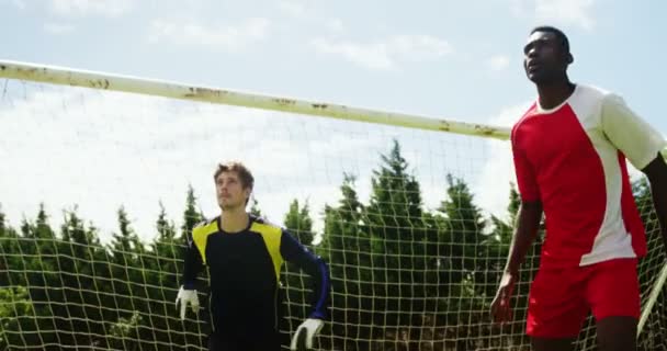 Dos jugadores de fútbol saltando para golpear una pelota — Vídeo de stock