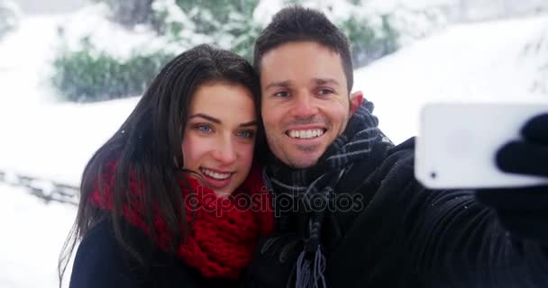 Ζευγάρι λήψη selfie στο κινητό τηλέφωνο κατά τη διάρκεια του χειμώνα — Αρχείο Βίντεο